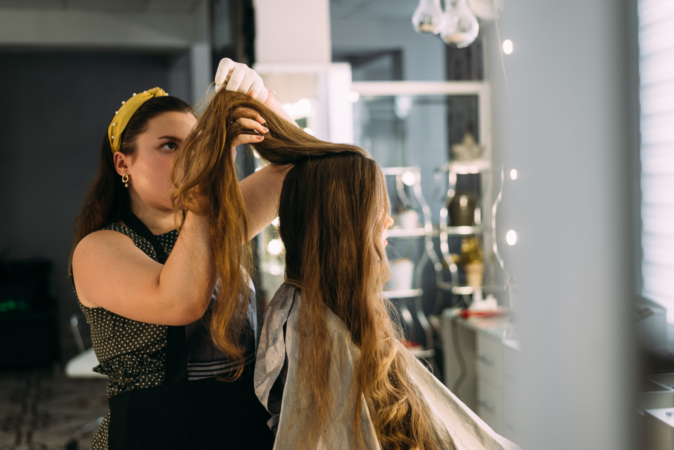 Stylist applying hair extensions at Secret Garden Hair Salon & Spa.